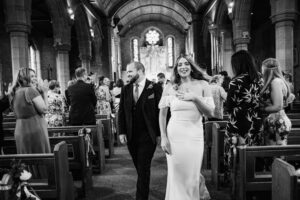 Wedding Florists in Sheffield take phot of bride and groom walking out of the church