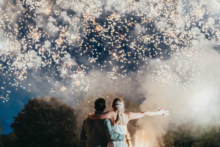 Happy couple under fireworks by Kirstie Garlick Photography